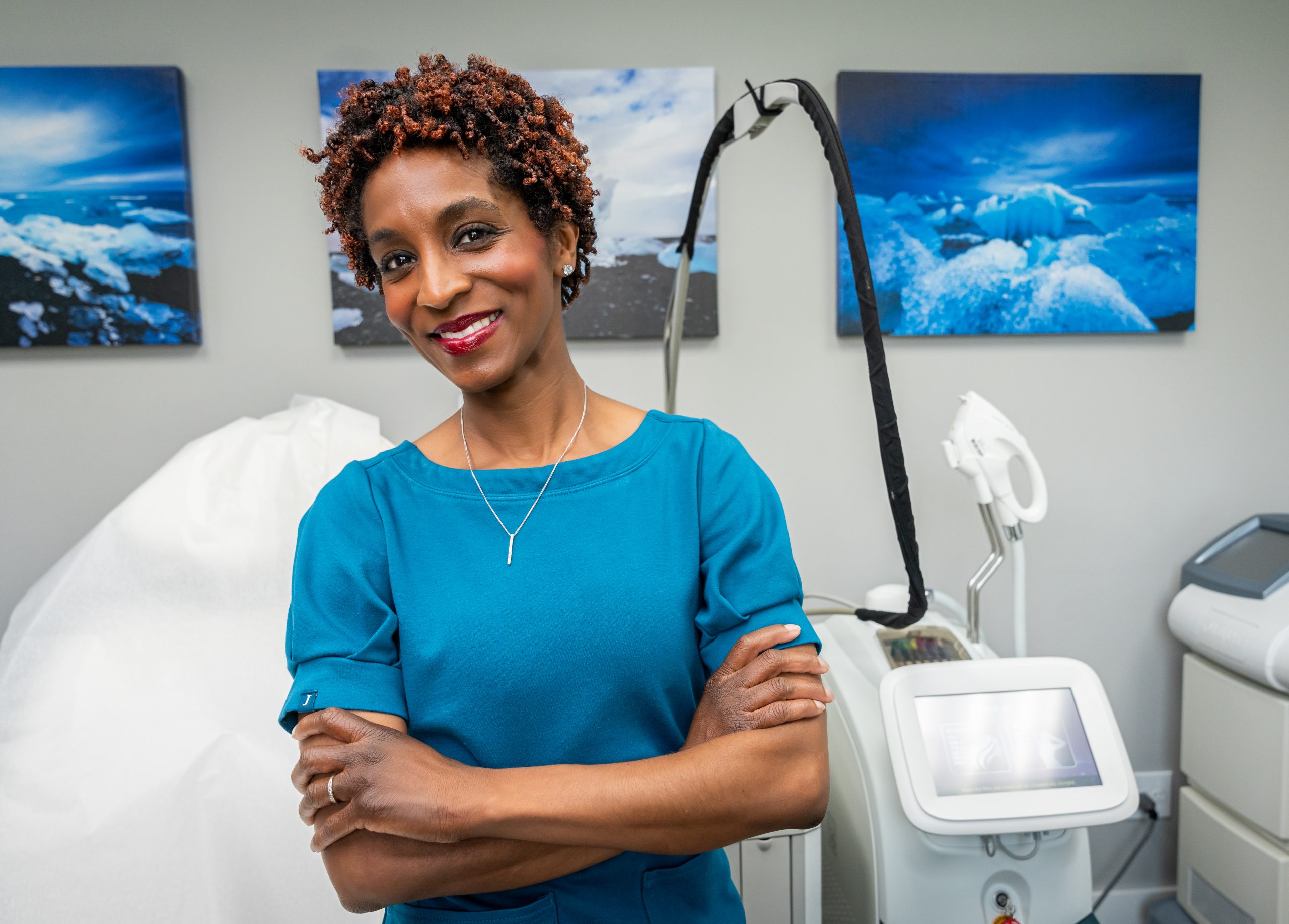 Dr. Kesha Buster smiling in front of cosmetic tools at her practice