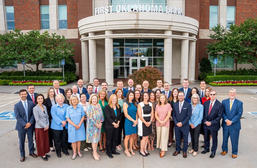 group of First Oklahoma Bank employees standing in front of the Jenks bank building